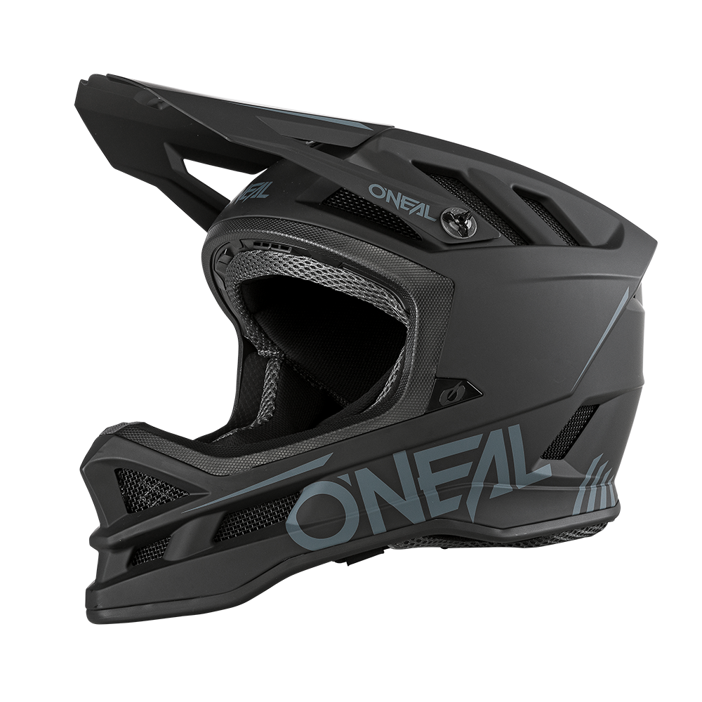 Ein schwarzer Integralhelm O'NEAL BLADE Polyacrylite SOLID zum Radfahren wird in einer Seitenprofilansicht gezeigt. Der Helm verfügt über eckige Belüftungsöffnungen, einen schützenden Kinnschutz und ein Markenzeichen in grauer Schrift an der Seite. Das Design ist schlank und aerodynamisch und unterstreicht seine Haltbarkeit und Sicherheitsmerkmale für jedes Mountainbike-Profil.