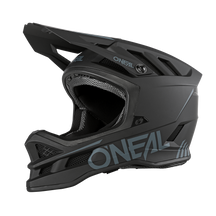 Ein schwarzer Integralhelm O'NEAL BLADE Polyacrylite SOLID zum Radfahren wird in einer Seitenprofilansicht gezeigt. Der Helm verfügt über eckige Belüftungsöffnungen, einen schützenden Kinnschutz und ein Markenzeichen in grauer Schrift an der Seite. Das Design ist schlank und aerodynamisch und unterstreicht seine Haltbarkeit und Sicherheitsmerkmale für jedes Mountainbike-Profil.