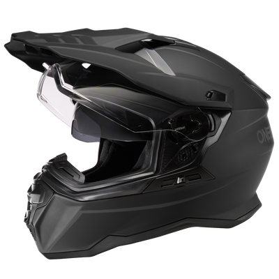 Der O'NEAL D-SRS Helm SOLID ist ein eleganter schwarzer Motorradhelm mit klarem Visier und aerodynamischem Design. Der Helm verfügt über Belüftungseinlässe oben und vorne sowie integrierte Sonnenblendensteuerungen. Die Innenseite ist für Komfort und Sicherheit gepolstert.