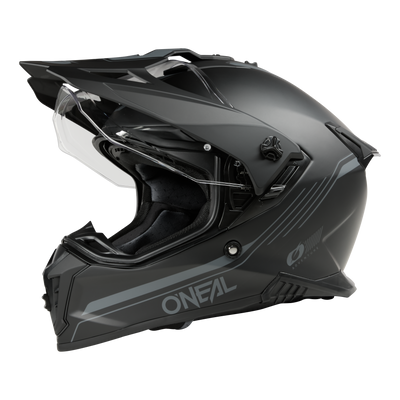 Der O'NEAL A-SRS Helmet SOLID ist ein mattschwarzer Motorradhelm mit transparentem Visier und elegantem Offroad-Design mit aerodynamischen Linien und zusätzlichen Belüftungsöffnungen. Das kultige O'Neal-Logo ziert die Seite vor einem schwarzen Hintergrund.