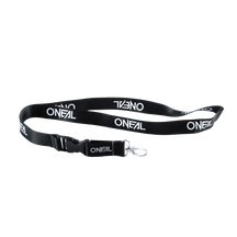 Das O'NEAL Lanyard der Marke O'NEAL ist schwarz mit dem Text „ONEAL“ in mehreren weißen Aufdrucken. Es verfügt über einen Schlüsselring aus Metall und einen Clip aus Kunststoff. Der Hintergrund ist schlicht und transparent.