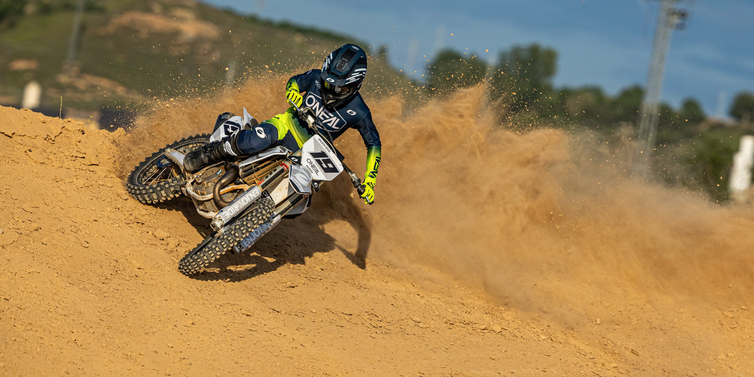 Motocross-Fahrer driftet durch eine sandige Kurve